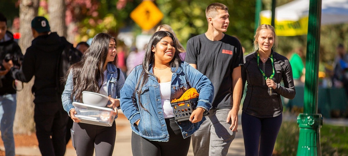 students walking and holding possessions during Unpack the quack day