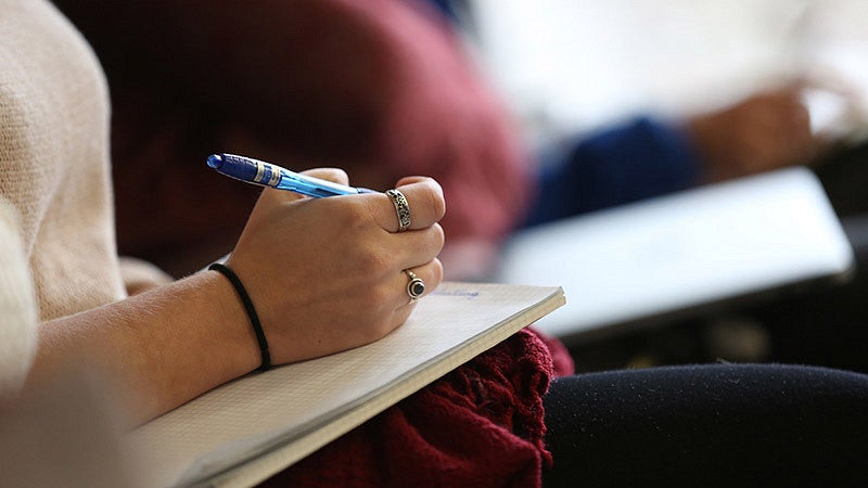 Person writing in a note pad