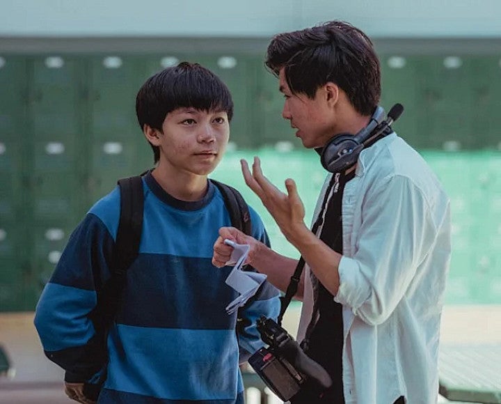 Two people in a hallway talking