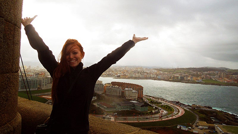 Student posing in front of view of a city below