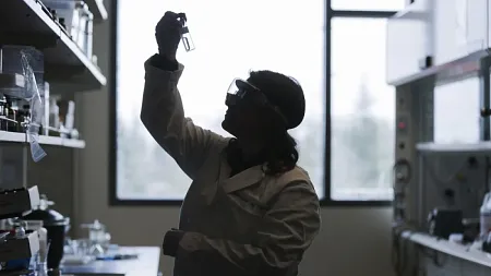 student holding up test tube in laboratory