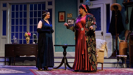 two people dressed in a 1920s era clothing on a theater stage