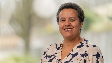 Photo of Camisha Russell smiling in a floral print top 