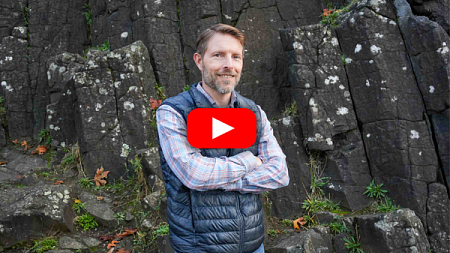 Dean Chris Poulsen stands in front of a basalt column in Eugene