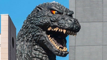 action figure of Godzilla screaming in terror in a city scape