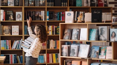 bookstore shelves with woman in background selecting books