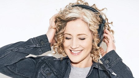 woman holding her headphones over her ears