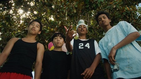 camera pointing up at four middle school boys standing in a semi-circle looking at camera