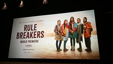 billboard with lights promoting Rule Breakers movie and featuring five Afghan women looking at the camera
