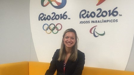 a person standing in front of Rio 2016 Olympics signs
