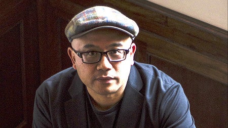 man wearing news cap and bold framed glasses looking at camera