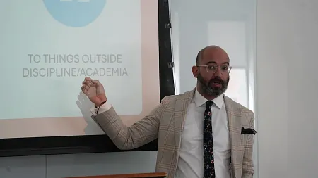 a person speaks in front of a slide during a presentation