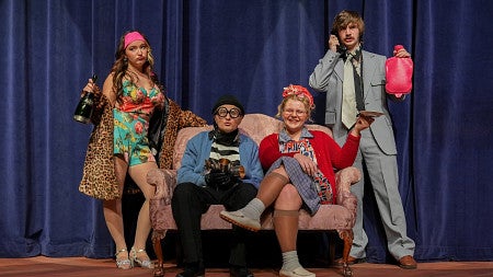 cast of noises off for University theatre standing on stage in character