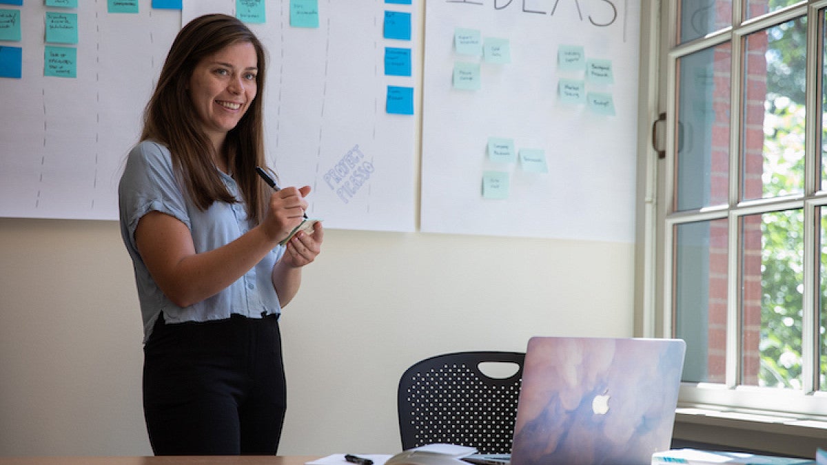 student in front of whiteboard with post-it notes