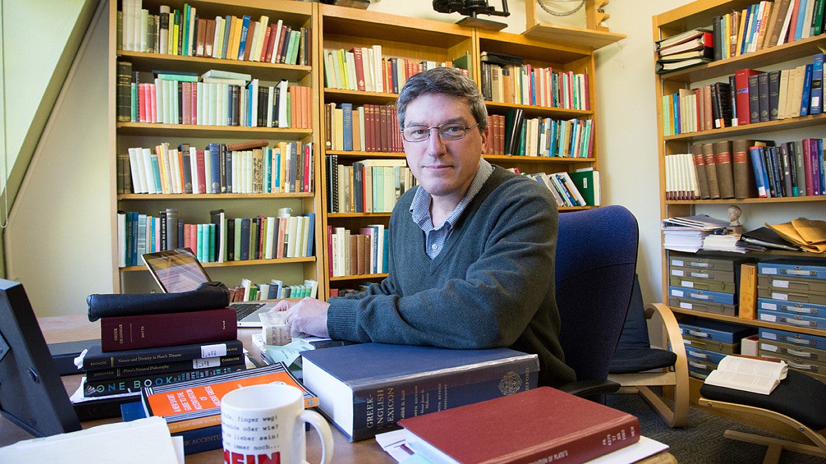 Malcom Wilson in faculty office with bookshelves. 