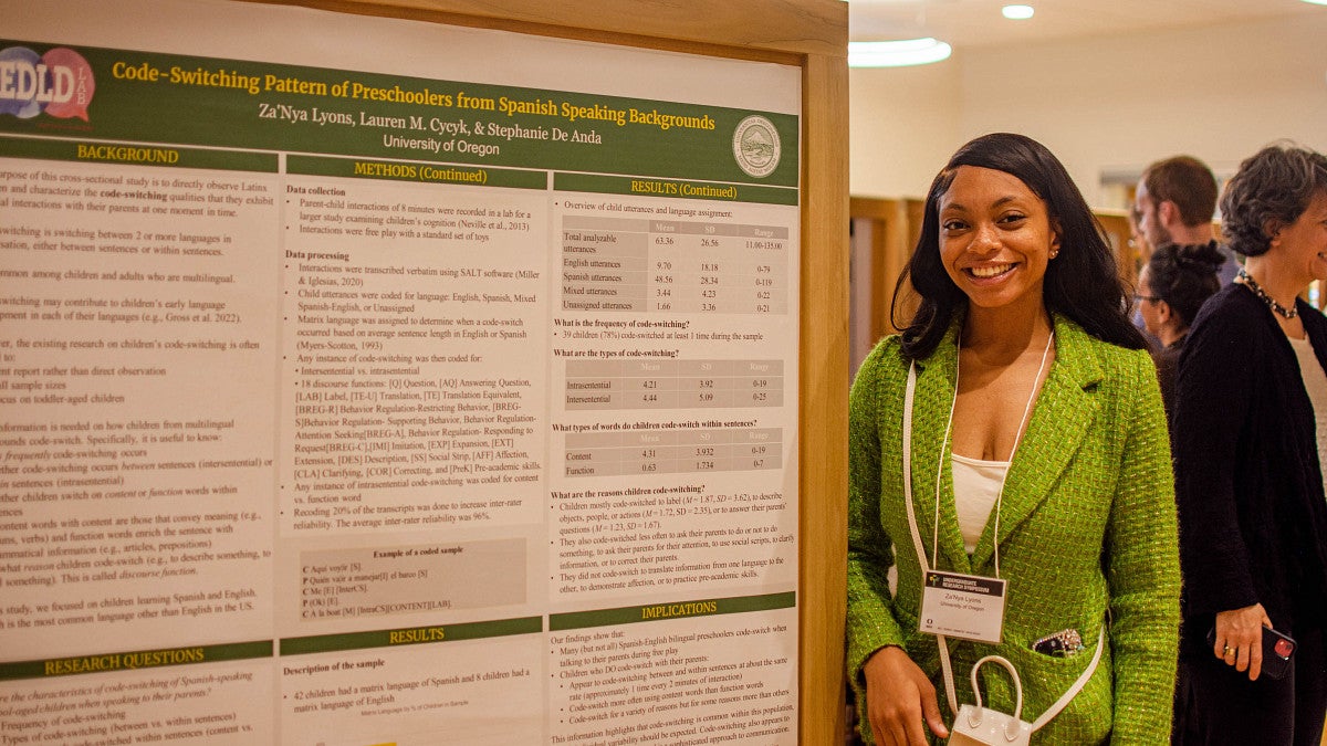 Student standing next to research poster