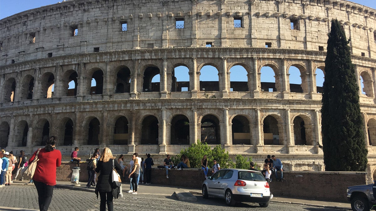 Ancient Colosseum with people in parking lot 