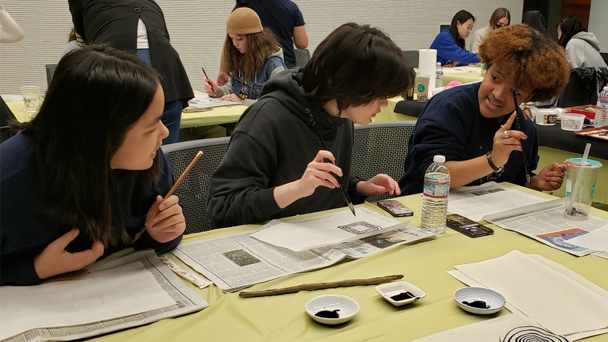 Students practice Chinese calligraphy