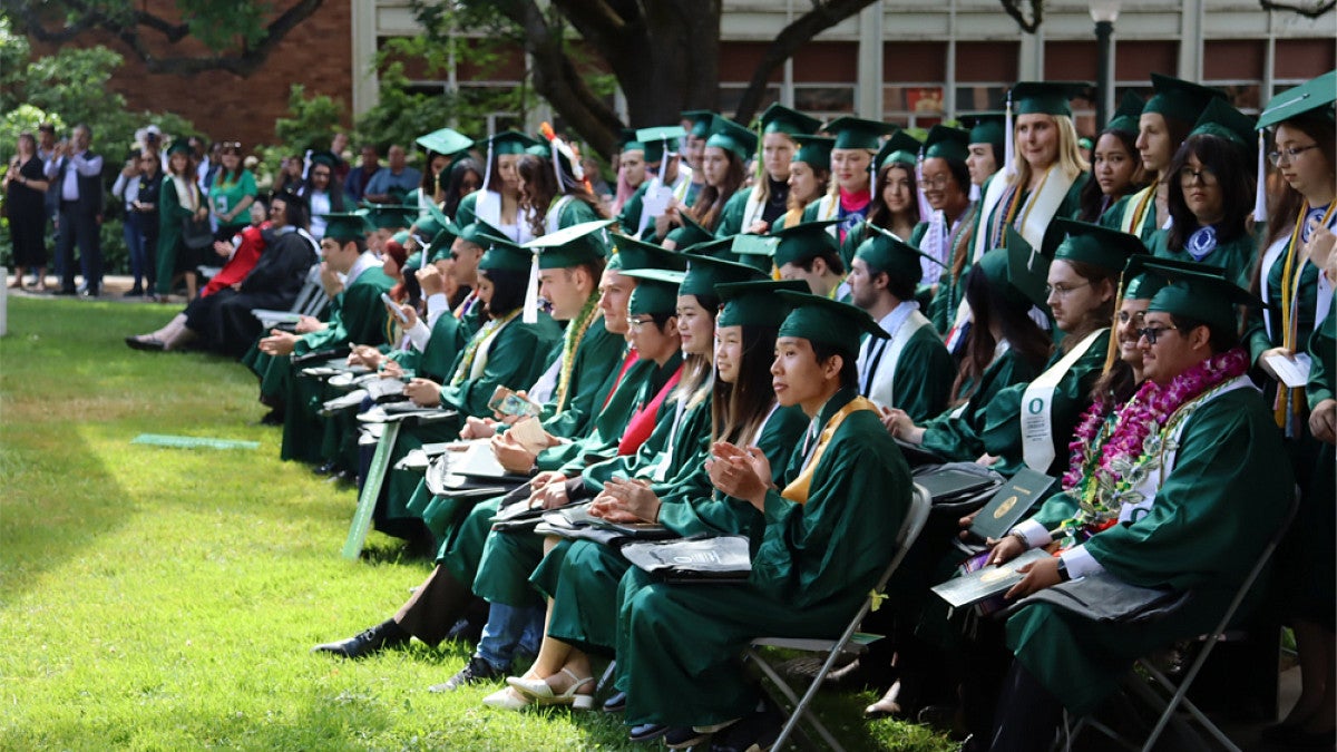 Students sitting on lawn for graduation