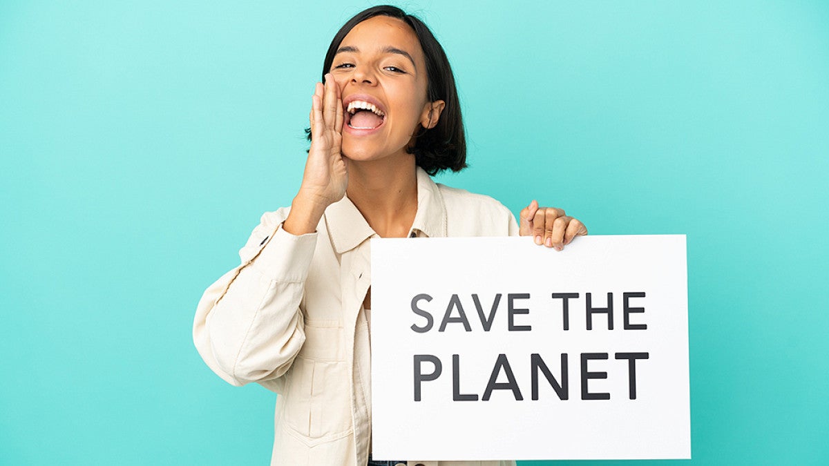 Person holding a sign with  "Save the planet" written on it