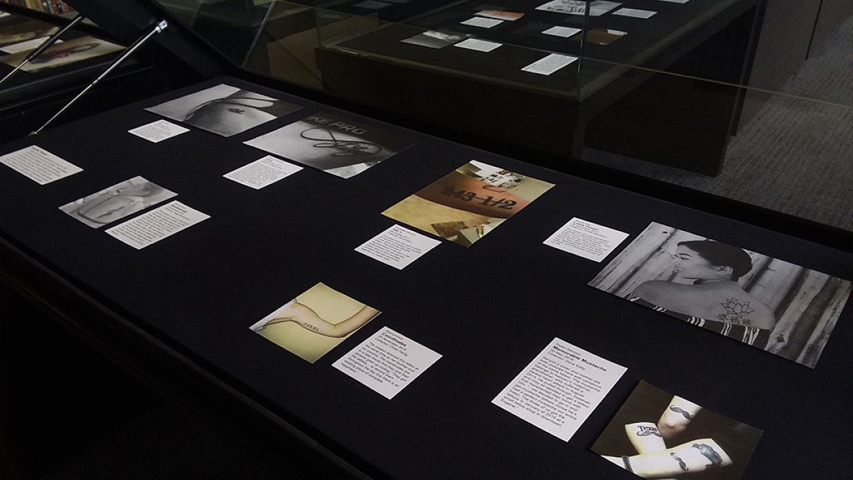 An research exhibit laid out on black table tops with photos and letters