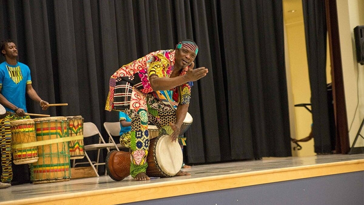 Person playing drums on stage wearing colorful clothes