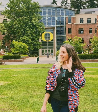 woman standing on university of oregon campus with a big O in the back