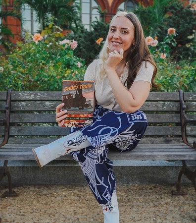 woman sitting on a bench holding a book