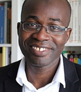 close up head shot of man smiling wearing glasses