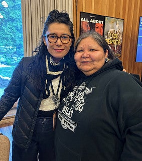 two women standing close with faces smiling for the camera