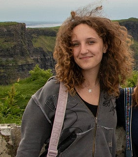 CAS alum standing on cliffs of moher with hair blowing