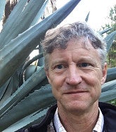 closeup of gordon sayre outside with aloe plant behind him