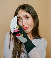 woman holding a sock puppet of a moon to the side of her face