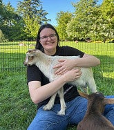 woman holding a goat and smiling