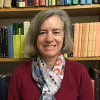 Head shot of Mary Jaeger smiling in front of a bookshelf.