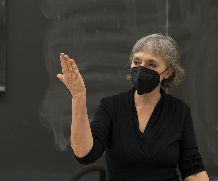 Classics professor Cristina Calhoon lecturing in front of blackboard