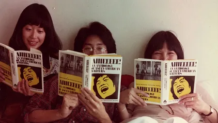 Contributors read copies of a 1976 Asian American literary anthology