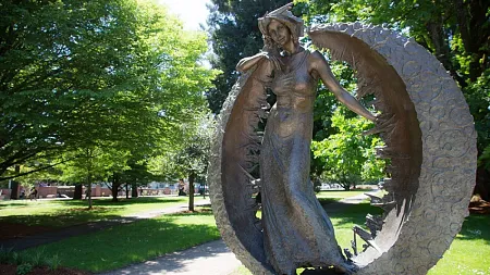 bronze sculpture of a woman standing within a circle