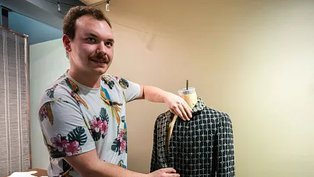 a student shows off a coat he designed